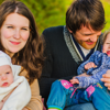 A young family sat together on a park bench.