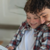 A father and his young son reading a book together, which is a great low cost activity