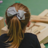 Young girl in a play area looking at a collapsed Jenga tower