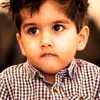 A young boy wearing a check shirt looking happy and safe