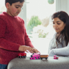 Parent watching their child playing with toy trains at home