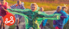 A group of kids running together wearing colourful rain macs