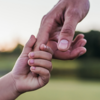 A child reaches out to hold their parents hand