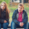 A group of four children talking to each other on a bench