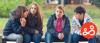 A group of four children talking to each other on a bench