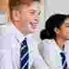 Teenagers at school sitting in a classroom smiling