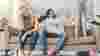 Man tries to stop child jumping on a chair while mum looks stressed