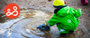 A young boy playing with a toy truck in a puddle