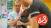 A dad carries his young child at a Saturdads session