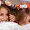 Two girls laughing while hiding under a blanket