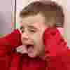 Autistic boy covering his ears and shouting