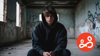 a young man is sat in a disused building, wearing a hoodie and looking directly at the camera