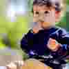 Toddler boy sitting alone on grass