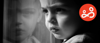 A blank-and-white photo of a troubled young child staring out of a window