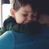 A prison father embraces his son during a visit from his family