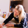 A children's counsellor helps a young girl working on a project 