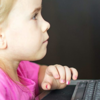 A young girl is browsing the internet on a desktop computer