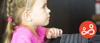 A young girl is browsing the internet on a desktop computer