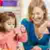 Mother watching as children thread onto pieces of string