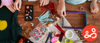 Two children are enjoying an art activity during the summer, on a table covered with art materials.