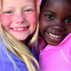 Two young girls looking very happy together