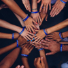 A team of volunteer's with hands stacked in a group huddle