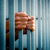 A prison father grasps the bars that separate him from the outside world and his family
