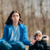 Parent with their child, meditating outdoors to deal with stress 