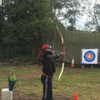 A young woman practicing archery with an instructor at an activity day organised by Spurgeons' BeLeave project