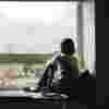 Boy sitting by his window staring out