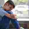 Boy sitting sadly by a window