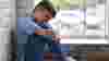 Boy sitting sadly by a window