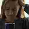 Teenage girl looking distressed holding her phone