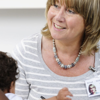 A mother and her child sit opposite a support worker, who is teaching a course that focuses on child mental health