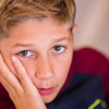 An anxious young boy with a troubled expression on his face