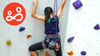 A resilient young woman ascending an indoor rock climbing wall